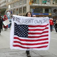 Marcher carrying U.S. flag - Trump doesnt own