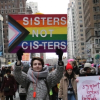 Holding Pride sign Sisters not Cis-ters
