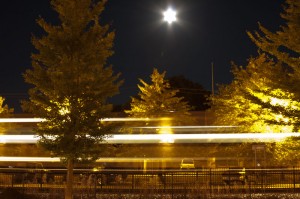 Harvest moon in village of Pawling with streaking train speeding by