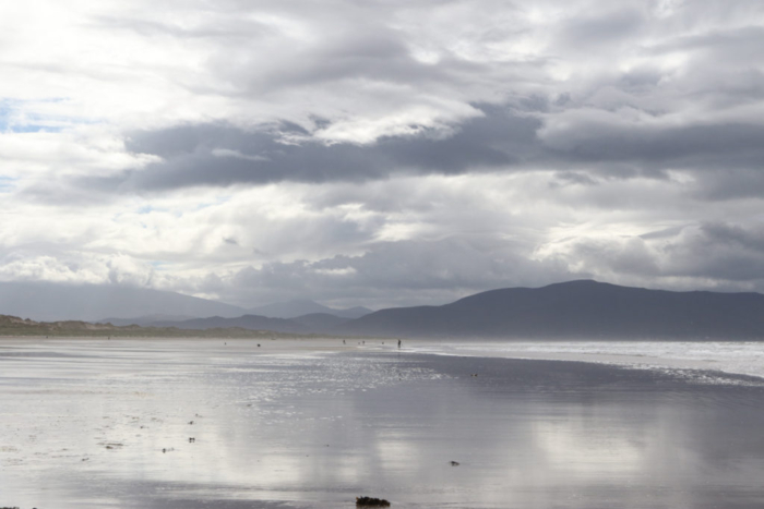 silvery clouds and light, distant mountains reflected in still waters