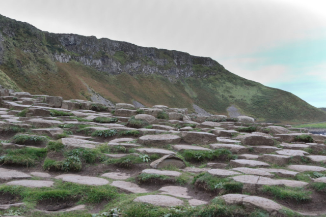 foreground basalt columns with towering cliff in distance