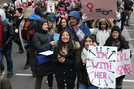 crowd with young women in front sign I'm with Her