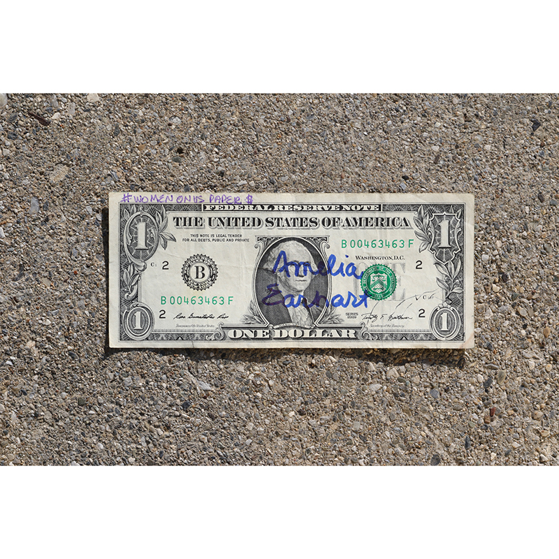 amelial earhart written with blue on a one dollar bill