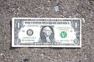 One dollar bill on cement background