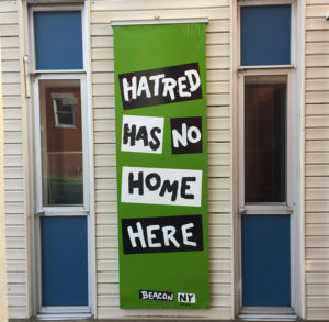 vertical banner black and white on green hatred has no home here