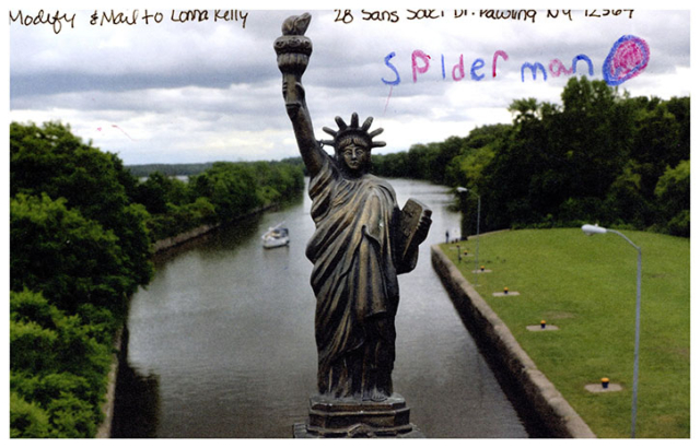 Spiderman written on sky by statue of liberty