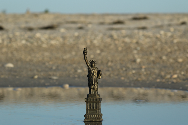 Statue of Liberty on beach at ocean Sand and salt pond behind