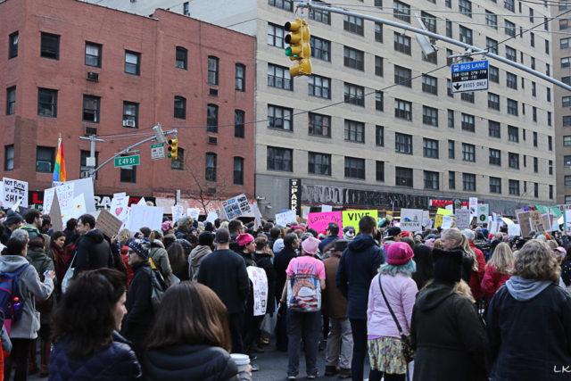 overview of large crowd taken from back of crowd large buildings in background