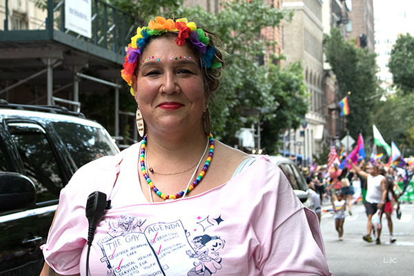 Person with pride colored flowers and tee shirt with the gay agenda 7.	Gender affirming care, mental services LGBTQ youth, abortion rights, protecting LGBTQ children