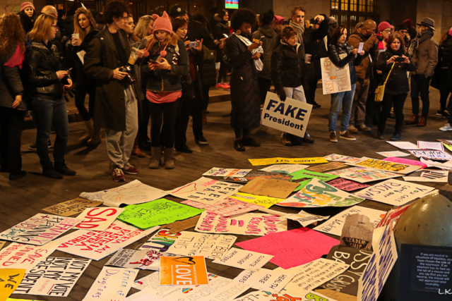 Grand Central station at end of march people have left signs on the ground crowd stops to read