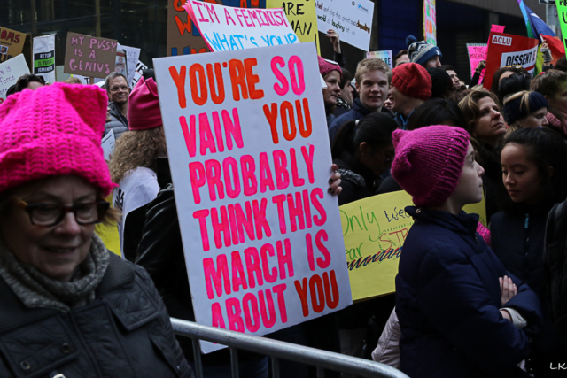 crowd some wearing pink pussy hats and protest sign reads You're so vain you probably think this march is about you