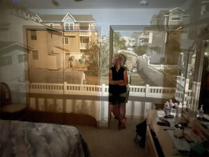 Camera obscura projection of outside view projected onto woman leaning on inside wall